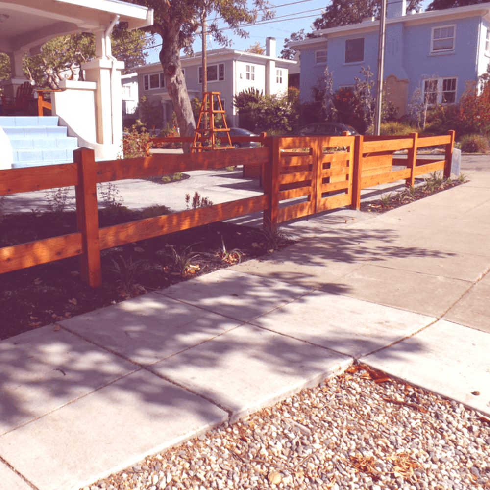 thicker wood frame picket fence protecting new garden install in Oakland neighborhood