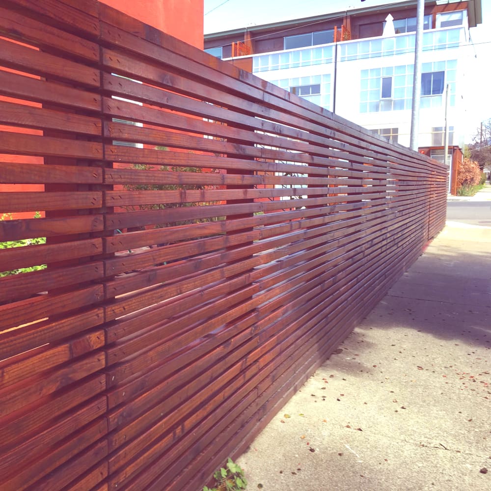 Unique privacy fence with horizontal wood strips and finish in Oakland complex